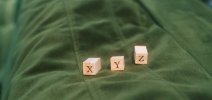 Wooden blocks with letters X, Y, Z on green fabric background.